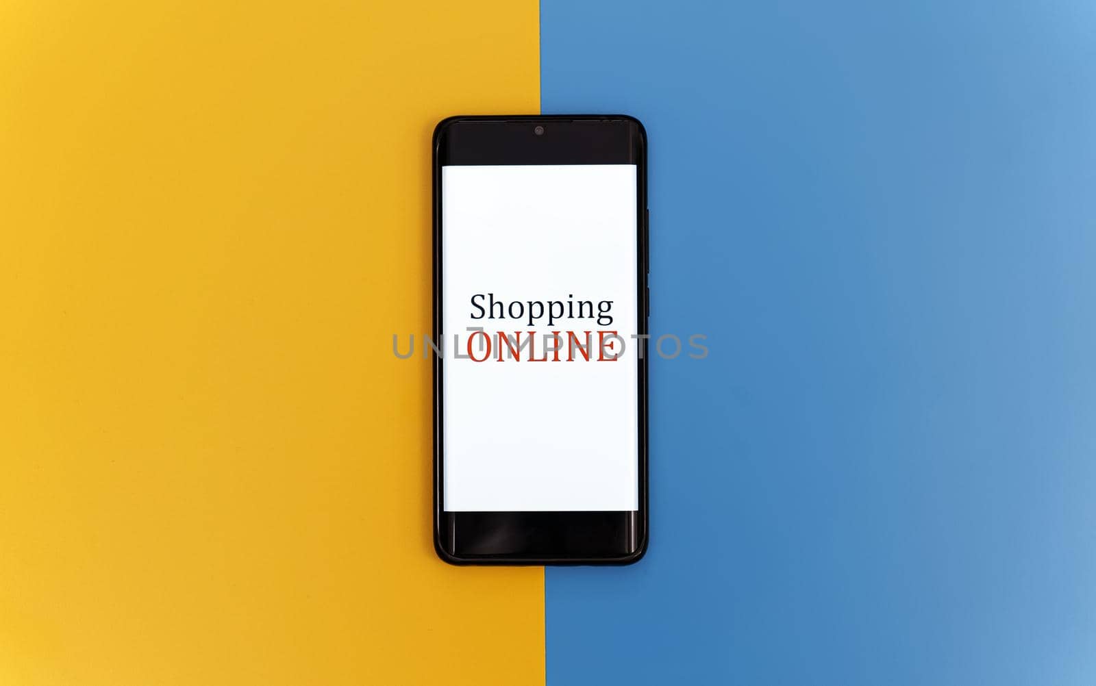 Smartphone on yellow and blue background. Online shopping concept.