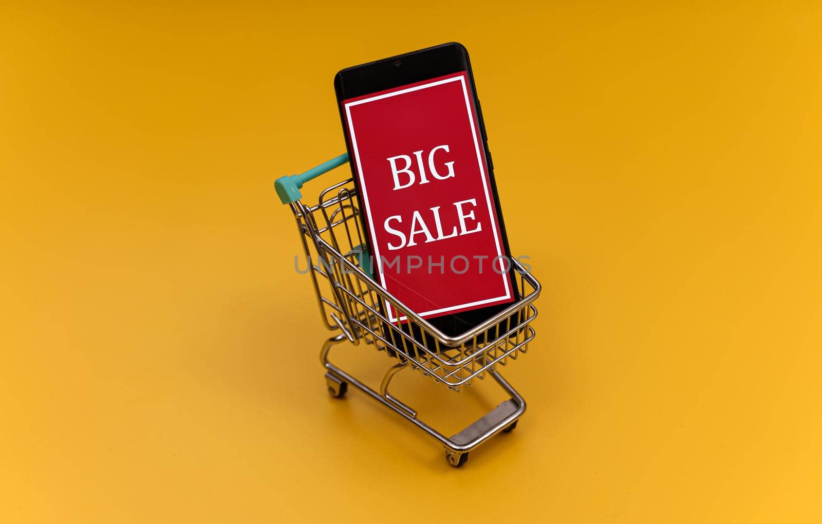 Shopping cart with smartphone. Big sale concept.