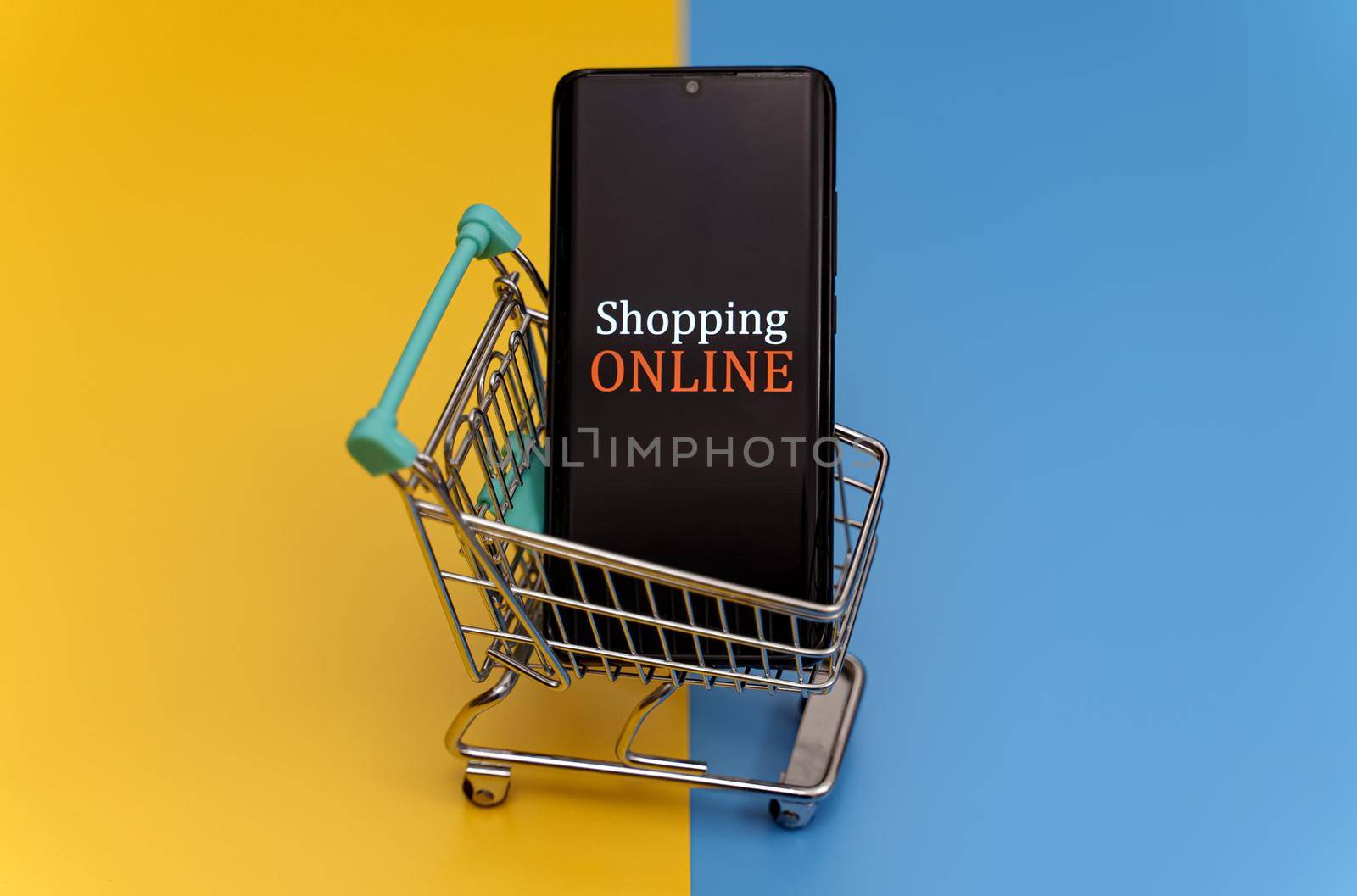 Shopping cart with smartphone. Online shopping concept. by dmitrimaruta