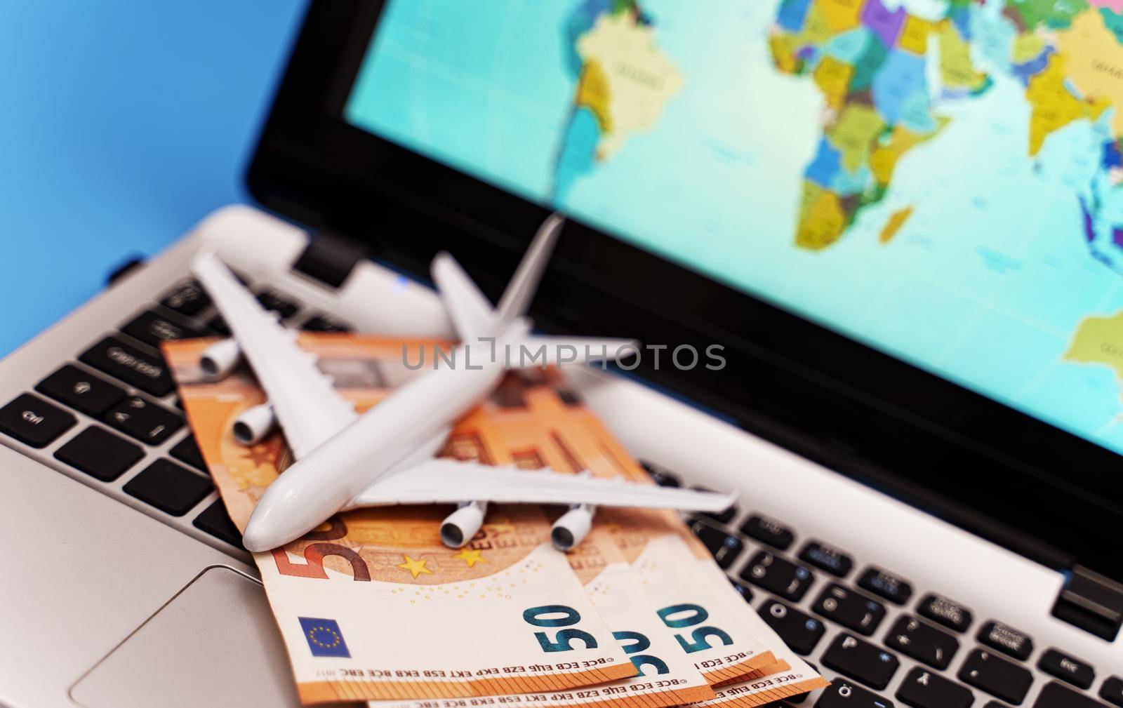 Toy plane on the notebook with world map. by dmitrimaruta