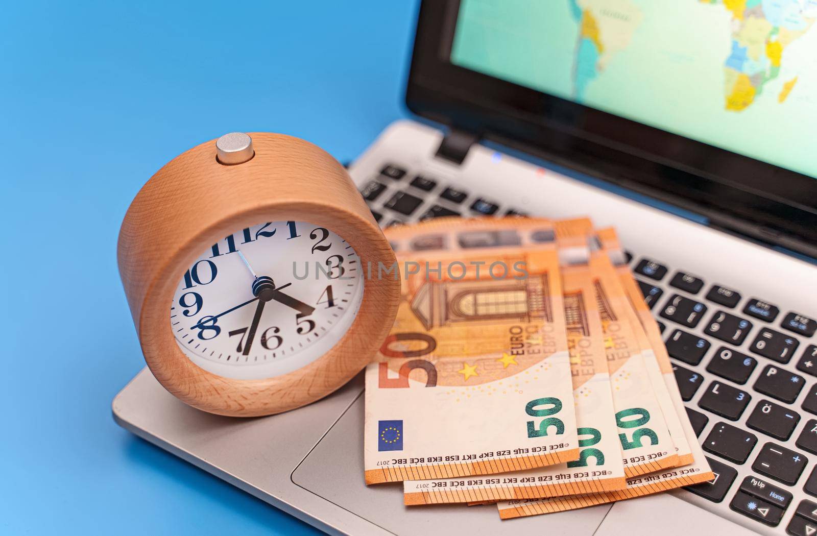 Time is money! Clock with euro banknotes on notebook. by dmitrimaruta
