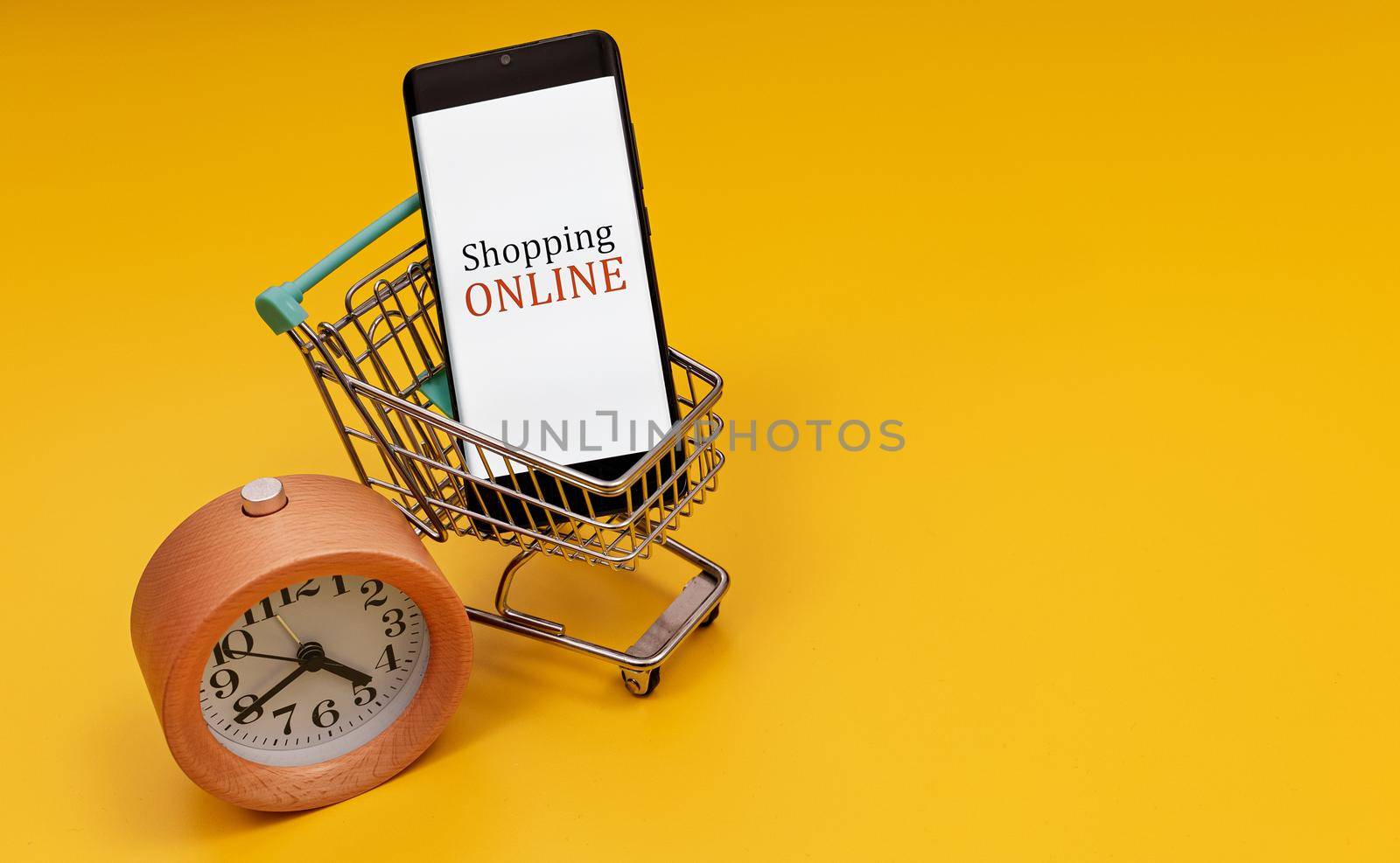 Shopping cart with smartphone and clock. Online shopping concept. by dmitrimaruta