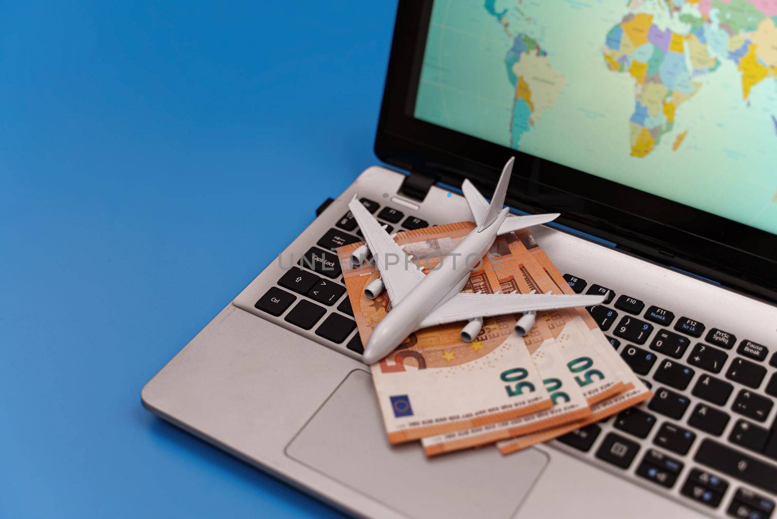 Toy plane on the notebook with world map. by dmitrimaruta