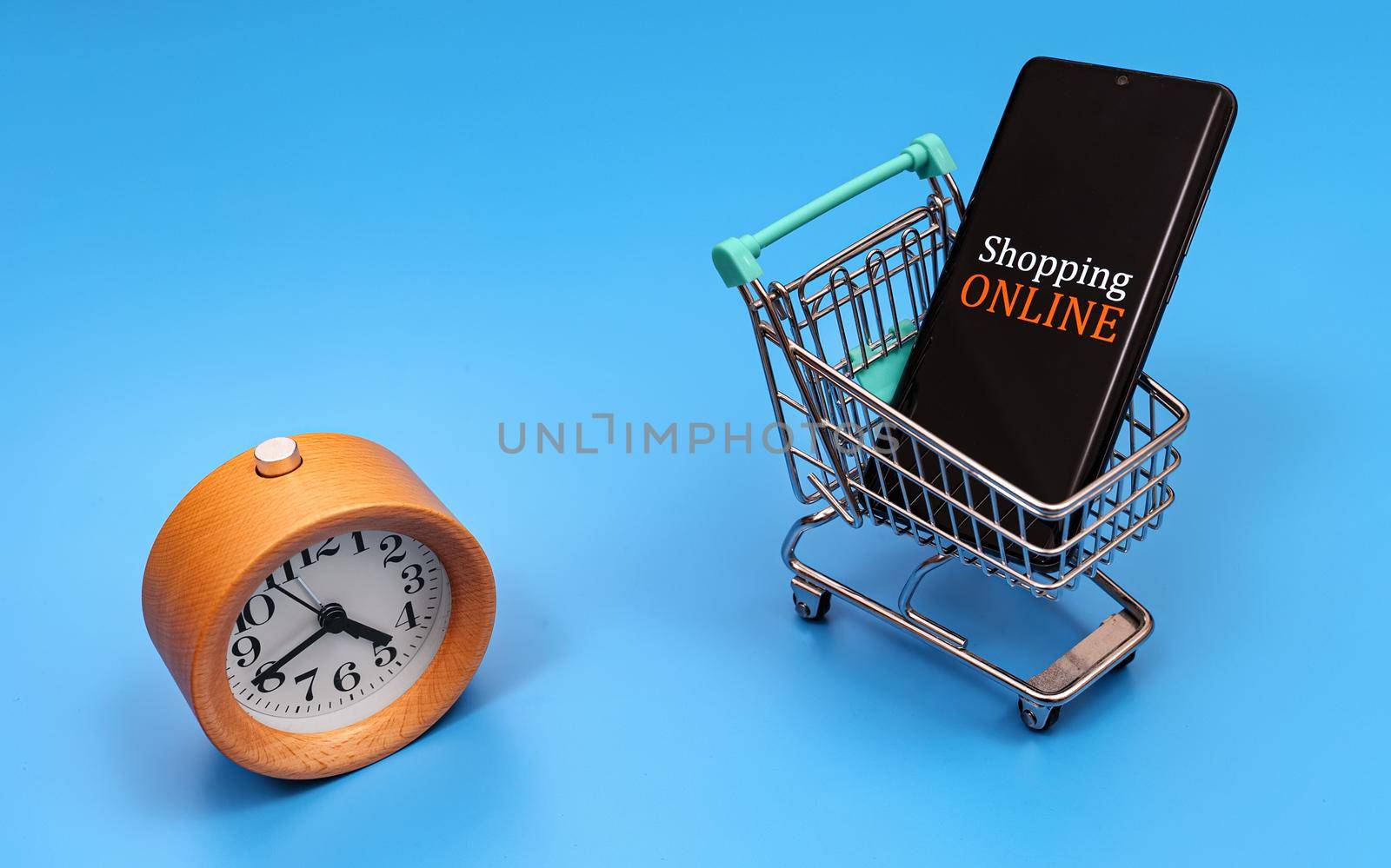 Shopping cart with smartphone and clock. Online shopping concept. by dmitrimaruta