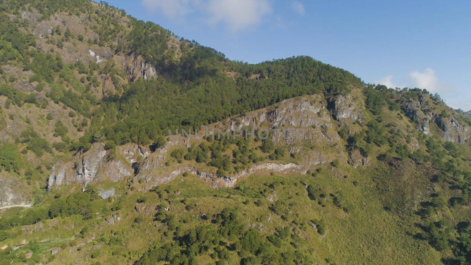 Aerial view of mountains covered forest, trees in clouds. Cordillera region. Luzon, Philippines. Slopes of mountains with evergreen vegetation. Mountainous tropical landscape.