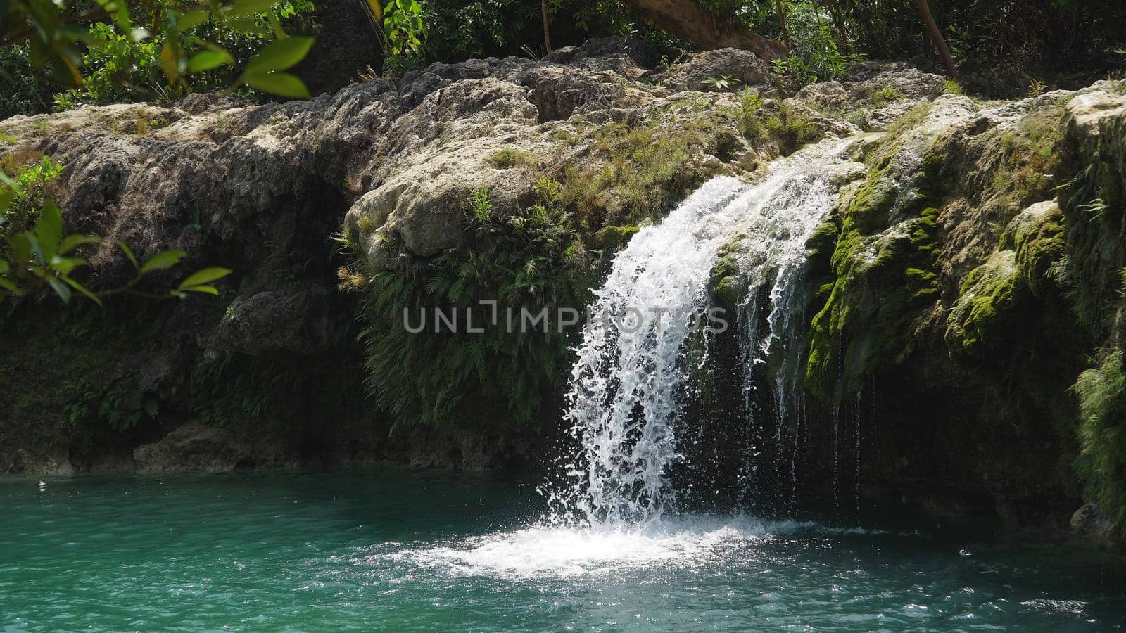 Waterfall in green rainforest. Bolinao waterfall in the mountain jungle. Philippines, Luzon. Travel concept.