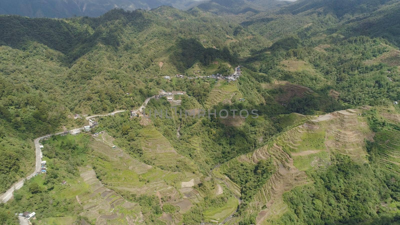 Aerial view of rice terraces on the slopes of the mountains, Banaue, Philippines. Rice cultivation in the North Batad. Mountains covered forest, trees. Philippine Cordilleras.