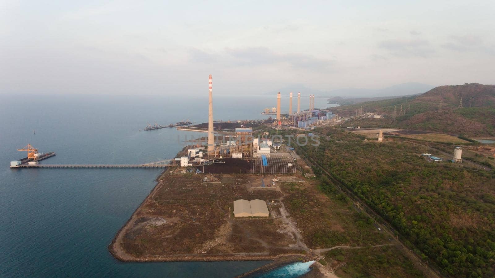 Aerial view Power station on the sea coast, Jawa island. Larger Industrial power plant in Indonesia. Power Plant cables and wires.