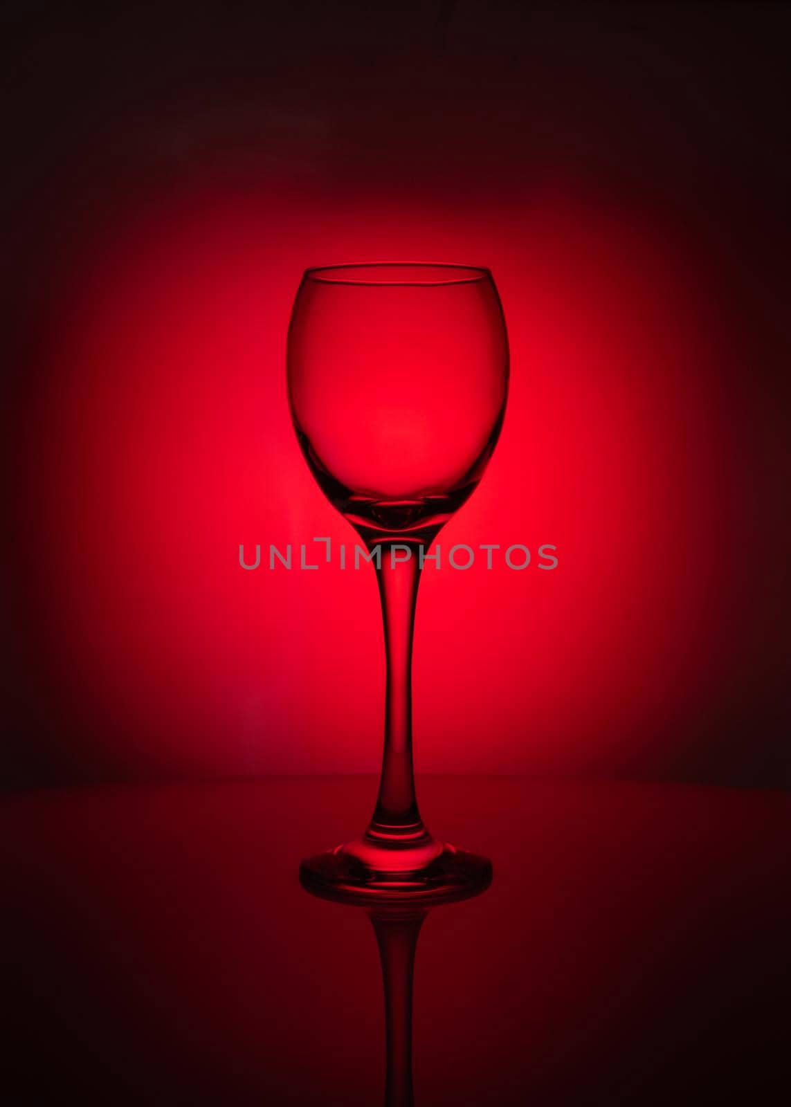 silhouette of transparent glass on red background