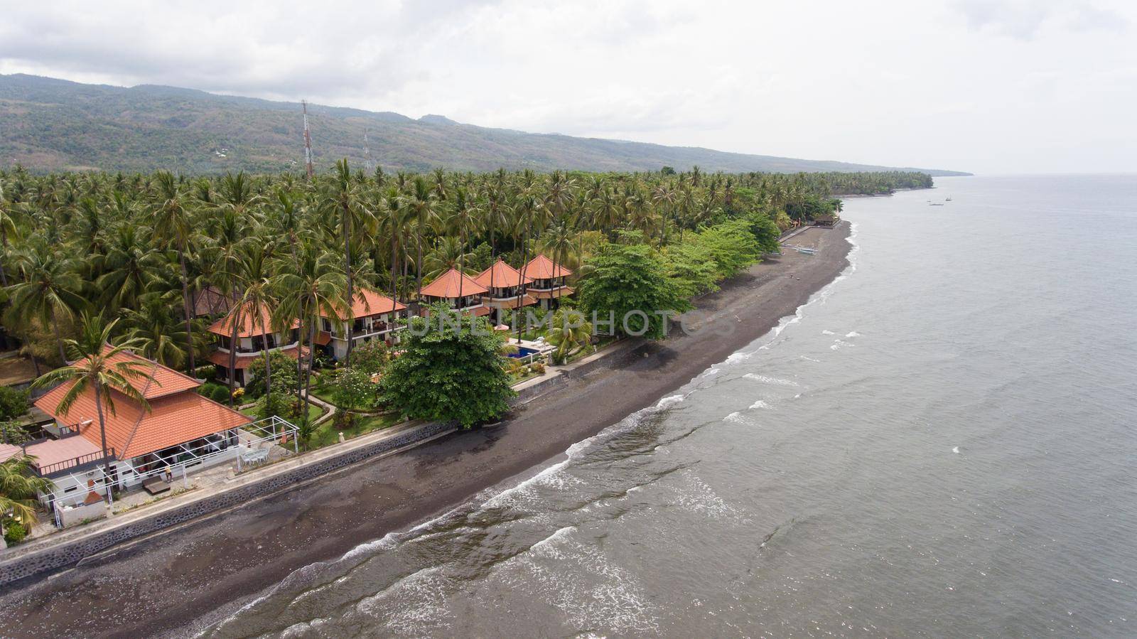 Aerial view of beautiful beach, hotel, Bali, Indonesia. Beach with black volcanic sand.Seascape ocean, sky, sea. 4K video Travel concept, Aerial footage.
