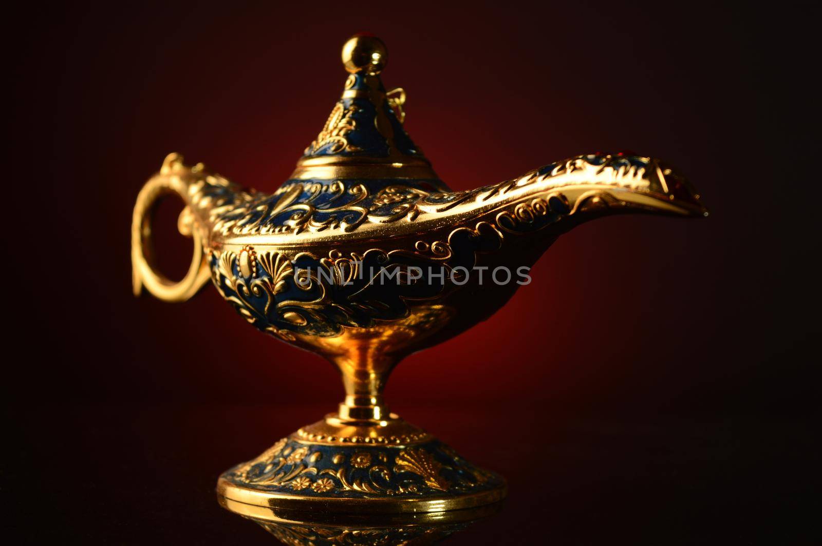 A magical ornate brass oil lamp over an atmospheric red and black gradient background.