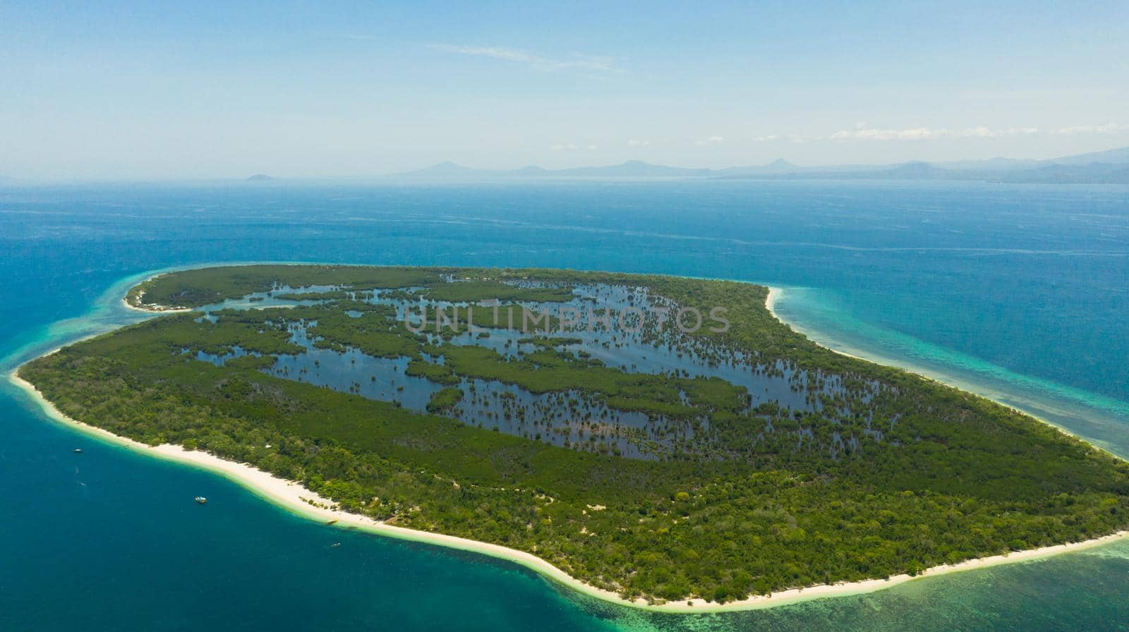 Island with a sandy beach and azure water surrounded by a coral reef and an atoll. Great Santa Cruz island. Zamboanga, Mindanao, Philippines.
