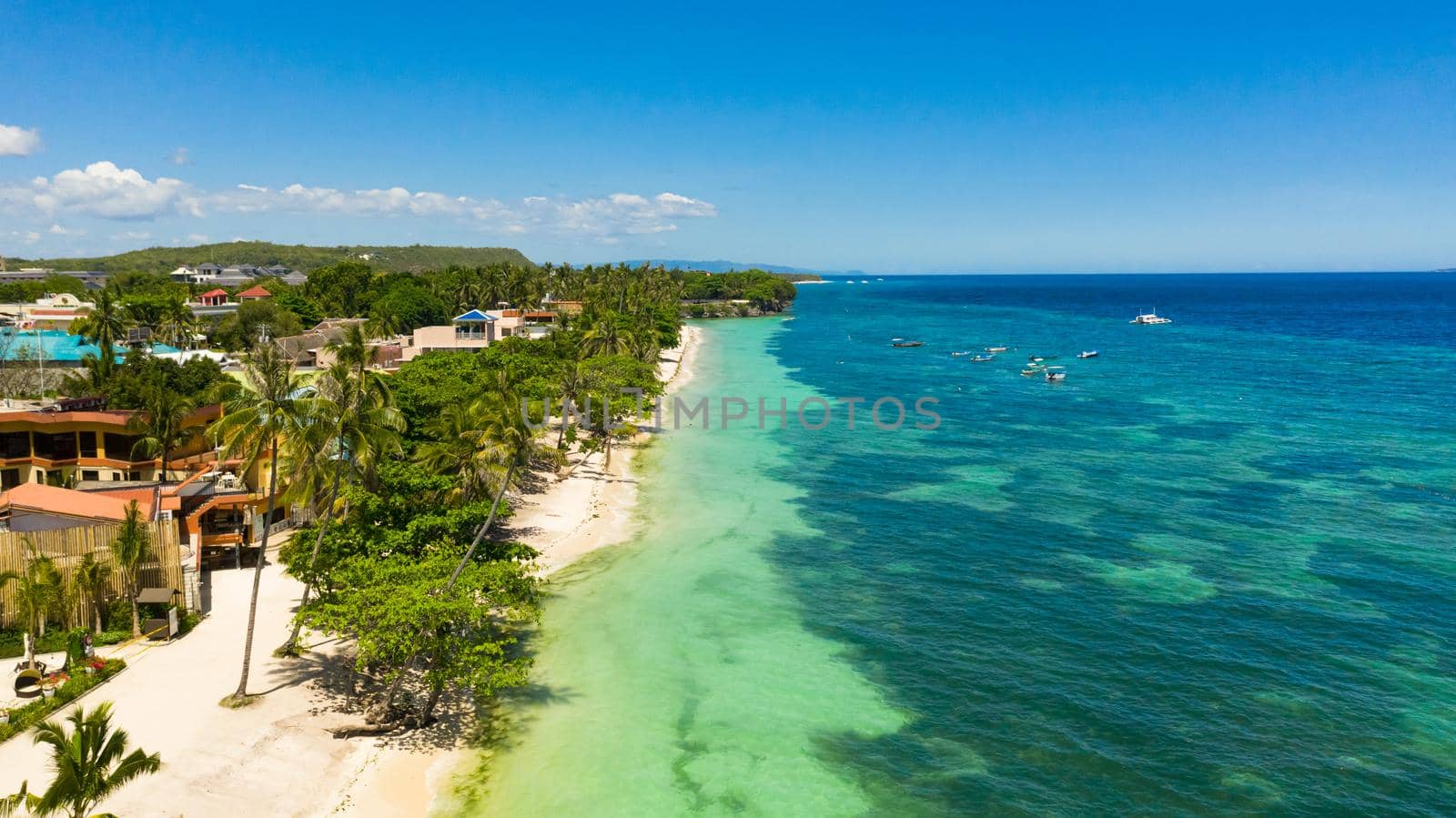 Tropical sandy beach with palm trees and turquoise clear waters. Alona beach, Panglao island, Philippines.