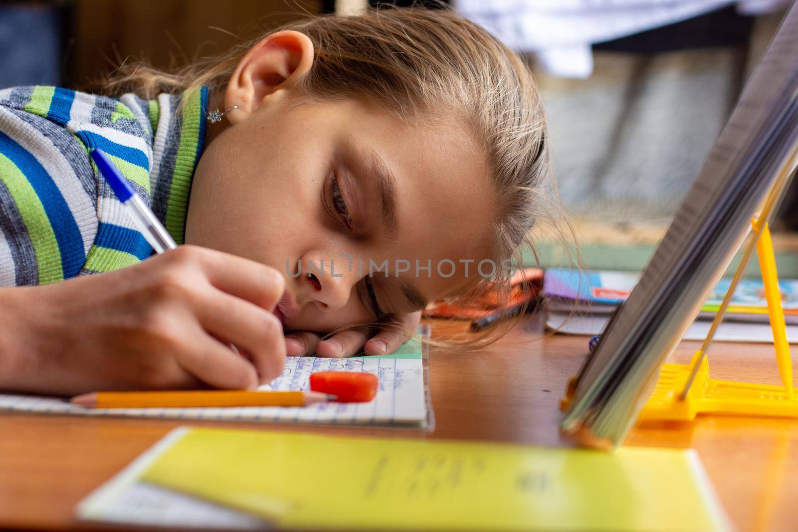 Girl from fatigue put her head on the table doing homework