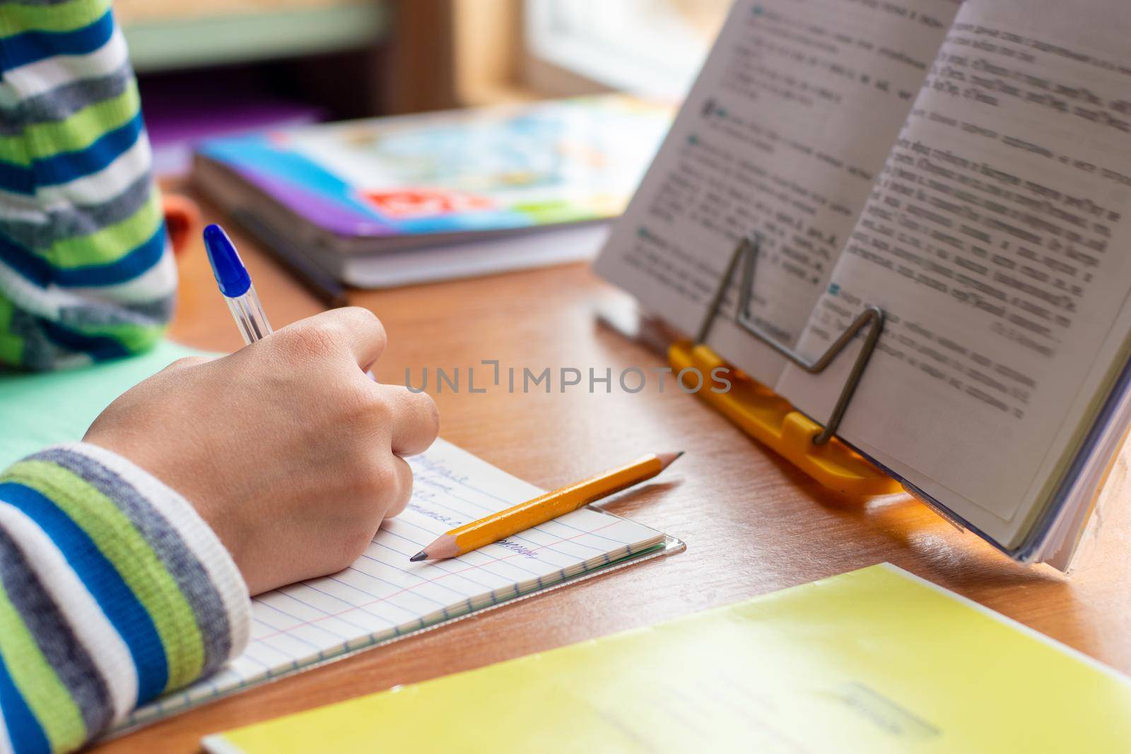 Close-up view of the hands of a schoolboy doing homework