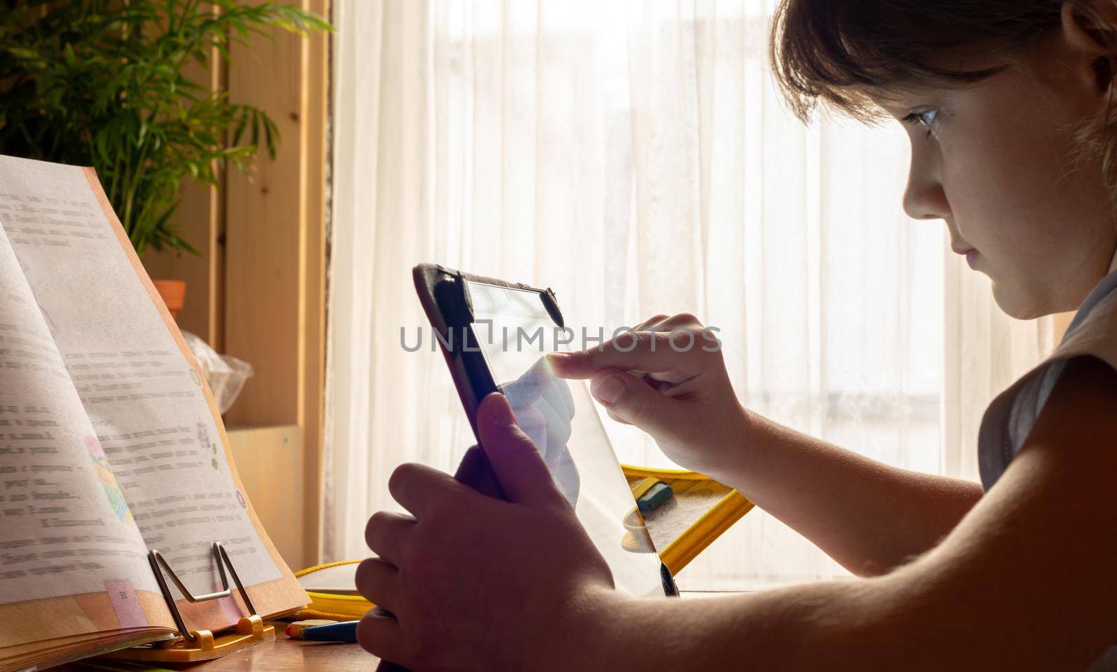 Girl studying online at home using tablet computer