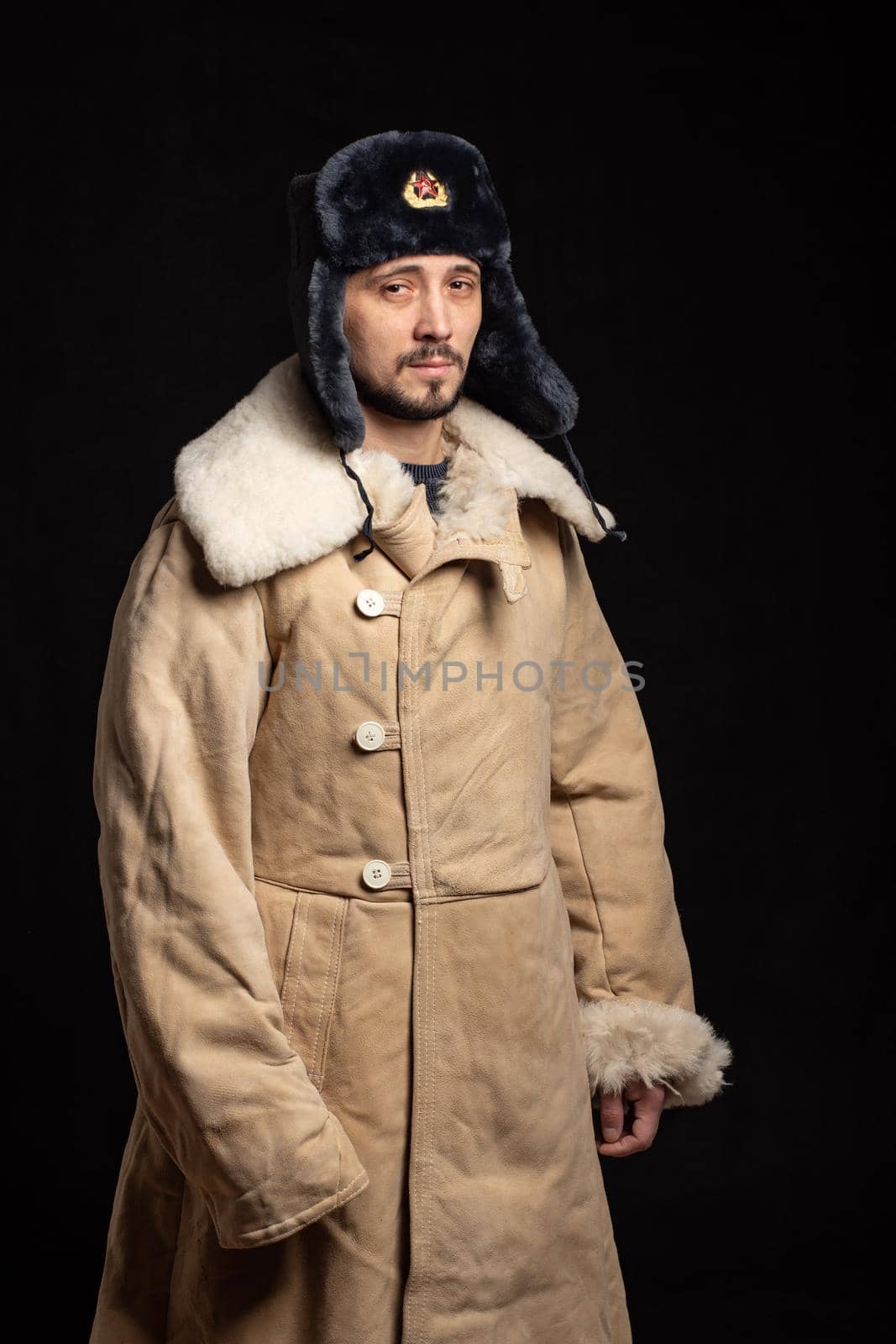 Portrait of a man of Caucasian appearance in a Soviet officer's fur hat and army sheepskin coat