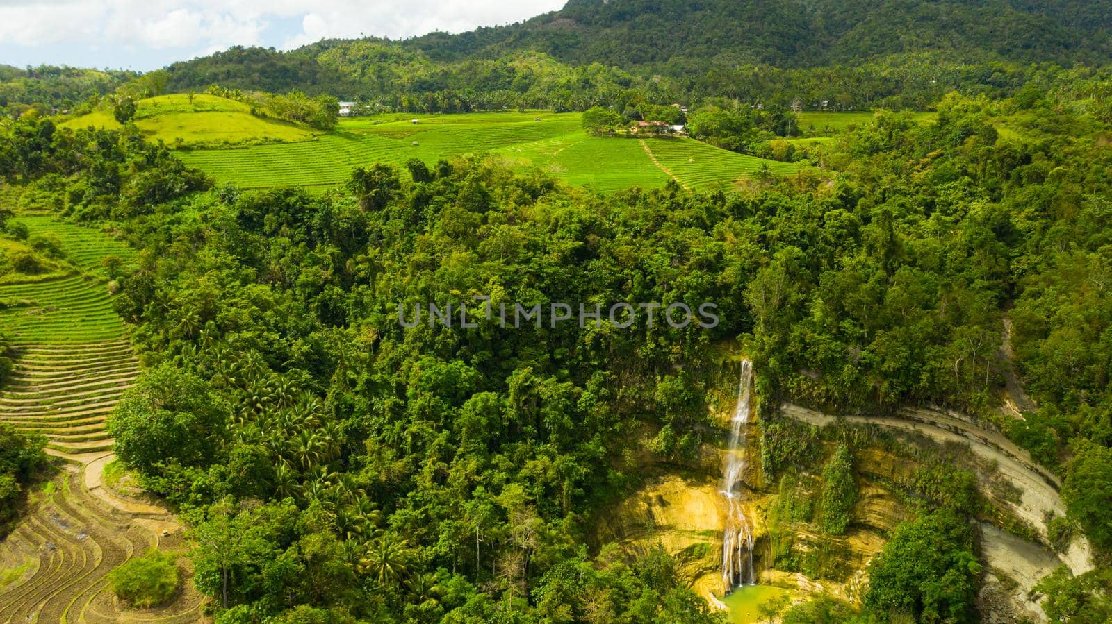 Tropical landscape: Beautiful waterfall and rice terraces. Aerial view of Can-umantad Falls.