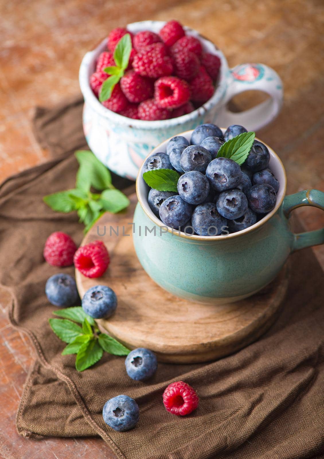 Ripe sweet raspberries in bowl on wooden table. Close up, top view, high resolution product by aprilphoto