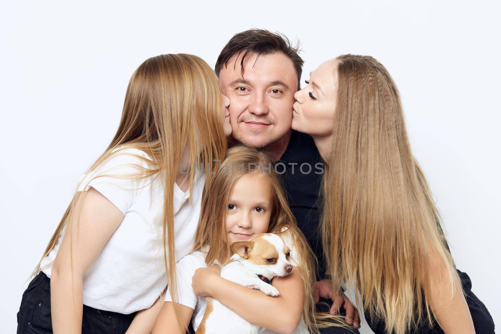 mom with daughter kissing father girl with dog in her arms family photo close-up. High quality photo