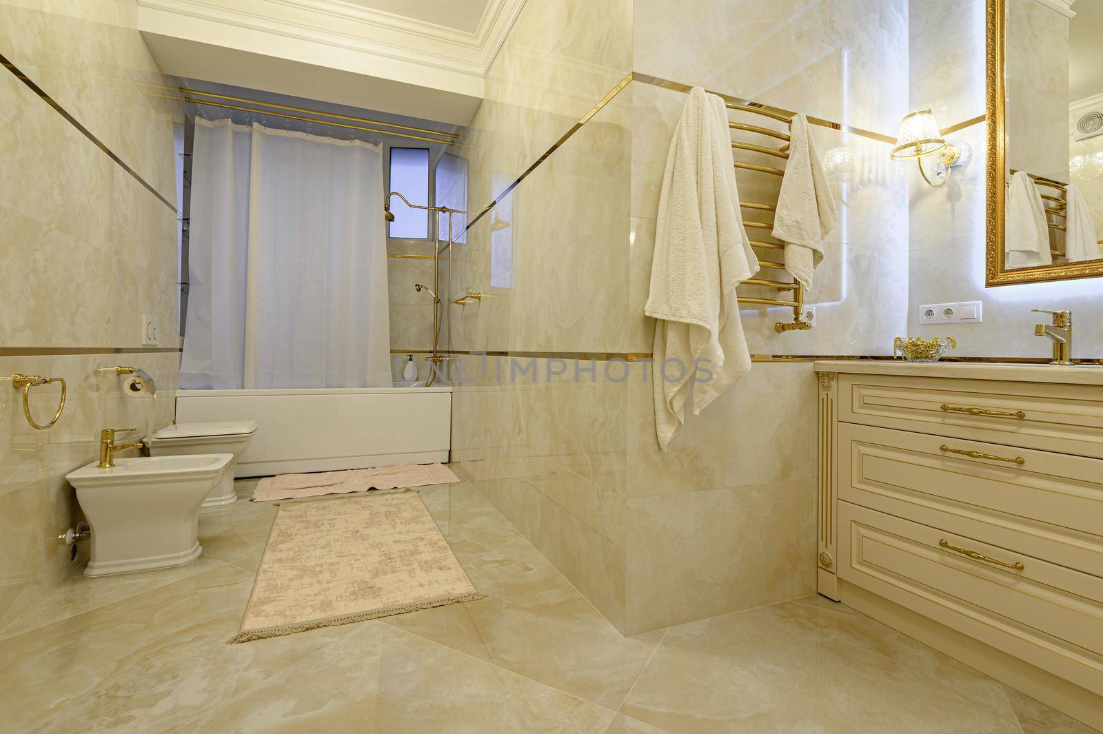 Modern luxury beige and golden bathroom with mirror, toilet, bidet and bathtub