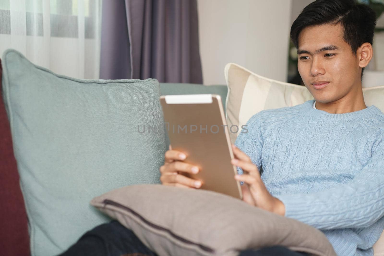 asian young teenage student man teenager entrepreneur working with tablet computer studying learning online at home. e-learning webinar meeting. social distance in covid pandemic