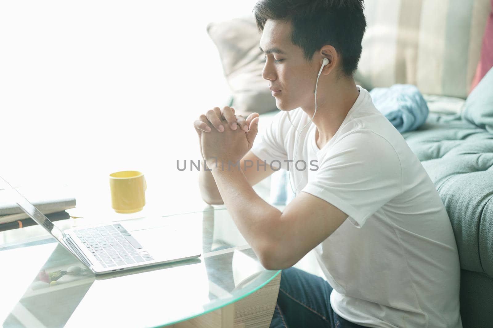asian young student man teenager entrepreneur wear earphones working with computer studying learning online at home. e-learning webinar meeting. social distance in covid pandemic
