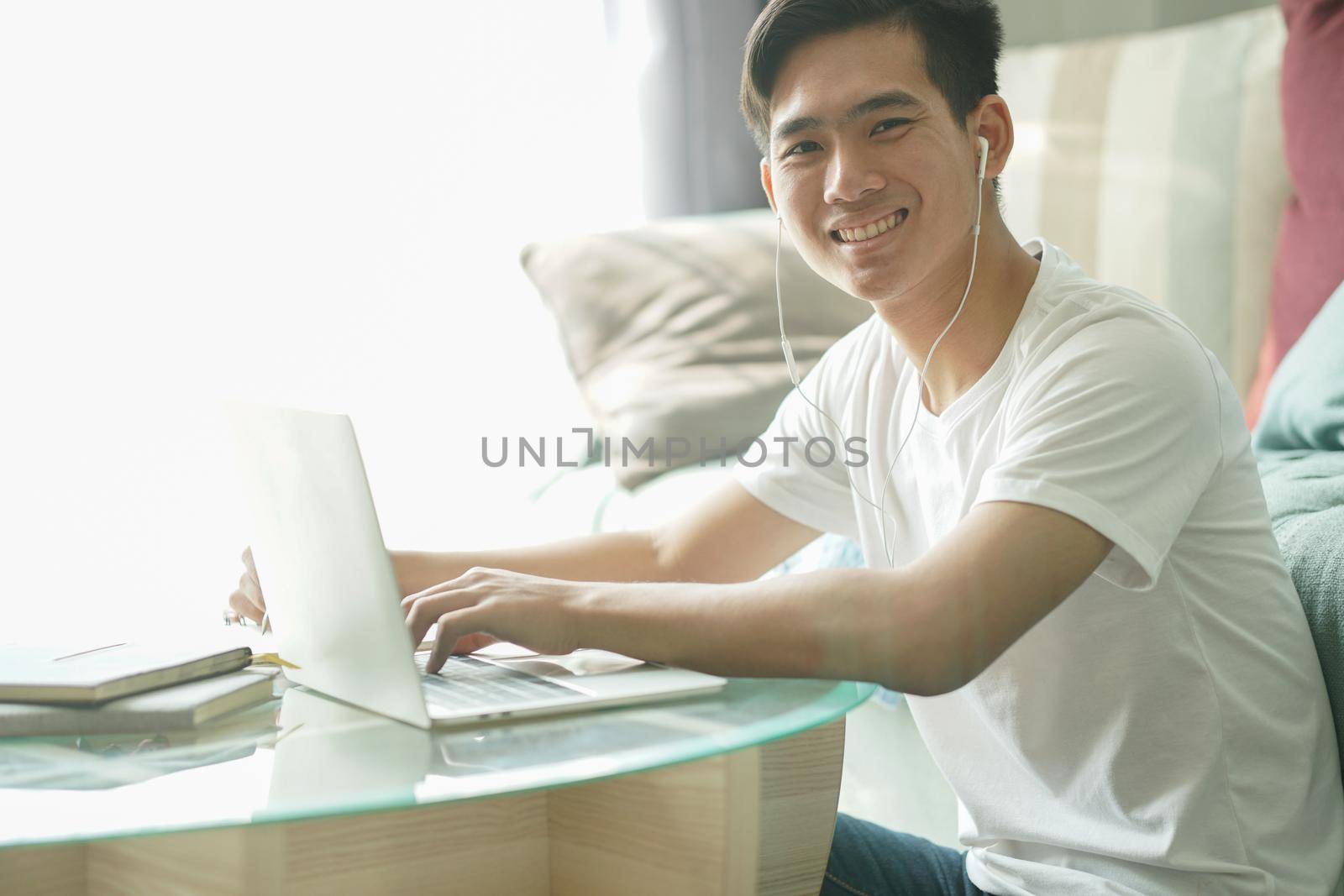 asian young student man teenager entrepreneur wear earphones working with computer studying learning online at home. e-learning webinar meeting. social distance in covid pandemic