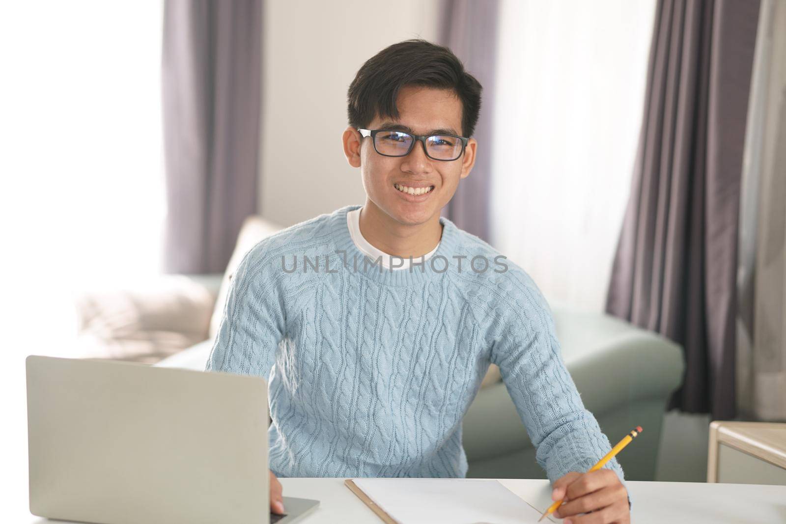 asian young teenage student man teenager entrepreneur working with computer studying learning online at home. e-learning webinar meeting. social distance in covid pandemic