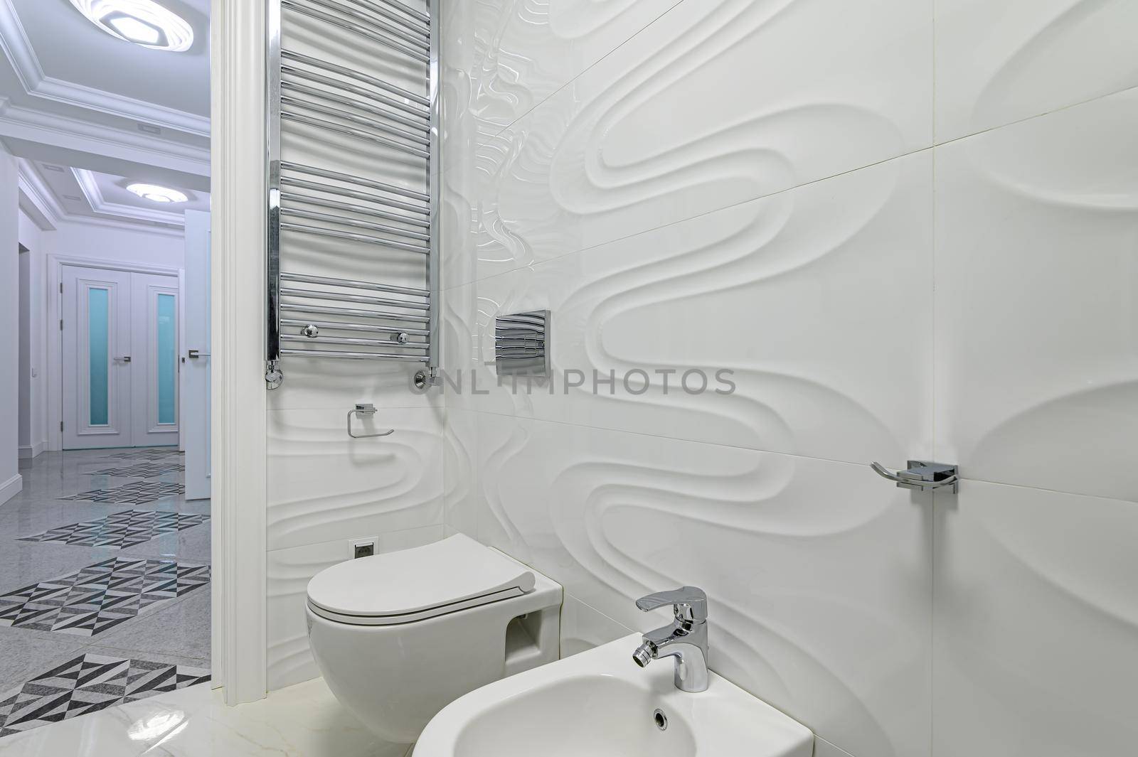 Modern luxury white and chrome bathroom with toilet seat, towel dryer and bidet