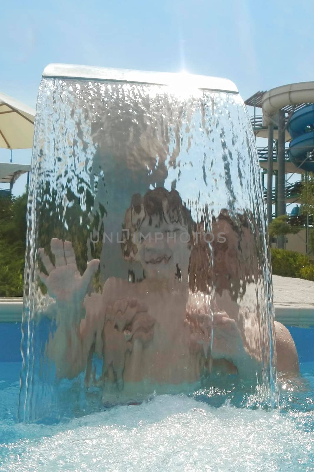 Portrait of a child in the water jets in the water Park.