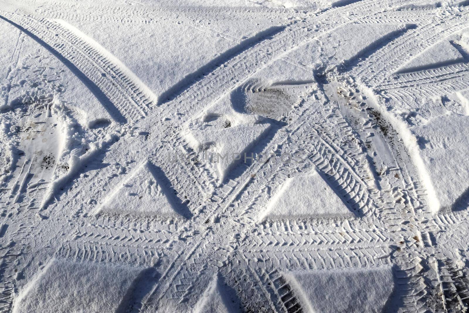 Tire Tracks on snow covered streets in a close up view. by MP_foto71