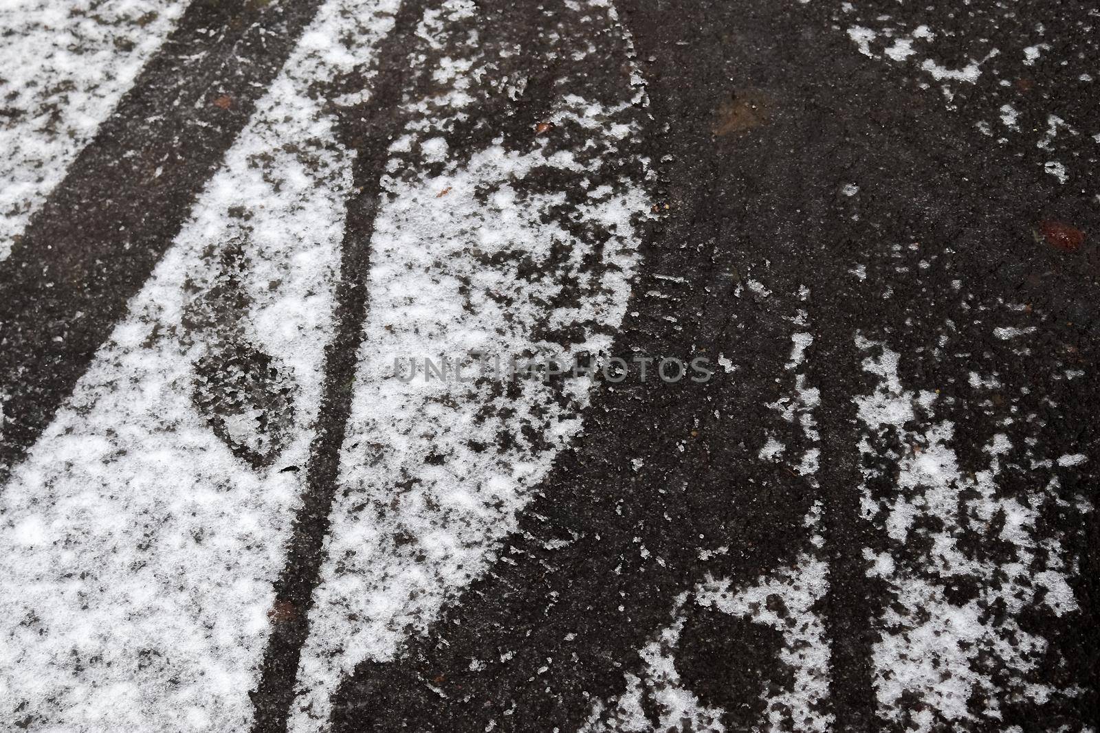 Dirty tracks of snow on asphalt on a small german road by MP_foto71