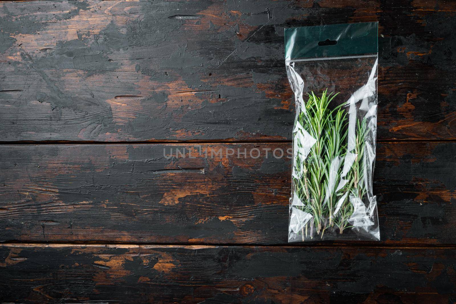 Fresh juicy Rosemary in market pack set, on dark wooden background, top view flat lay , with copyspace and space for text