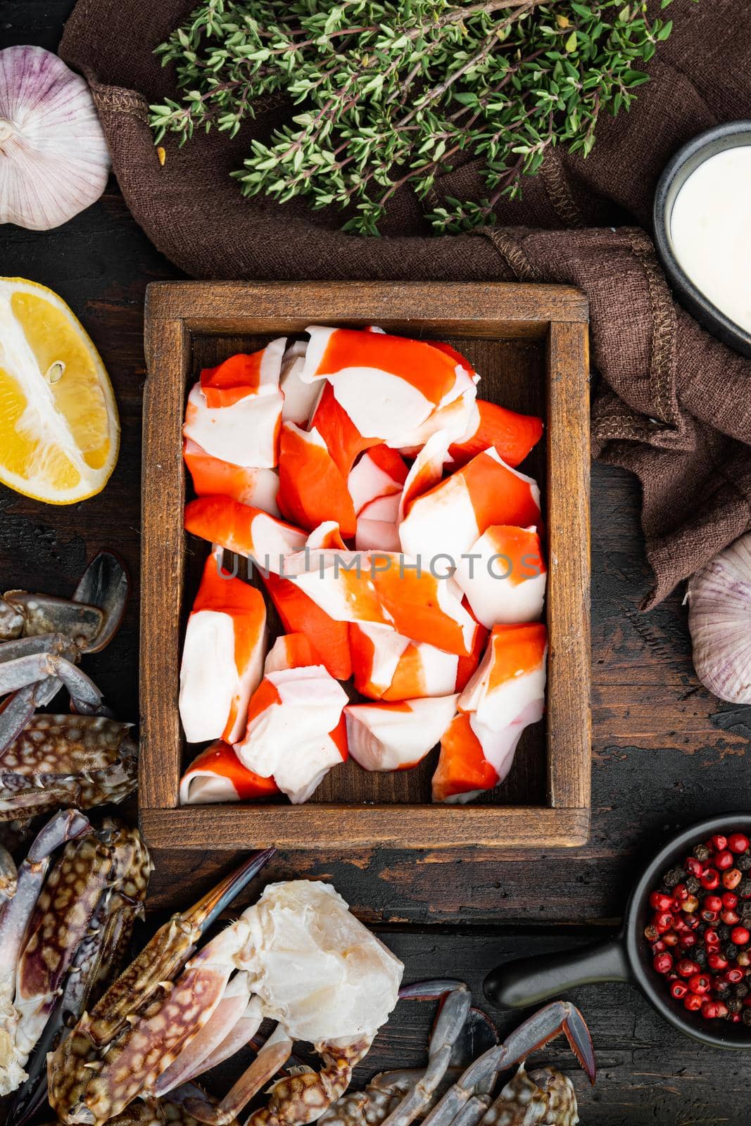 Fresh Crab meat stick surimi set, in wooden box, on dark wooden background, top view flat lay