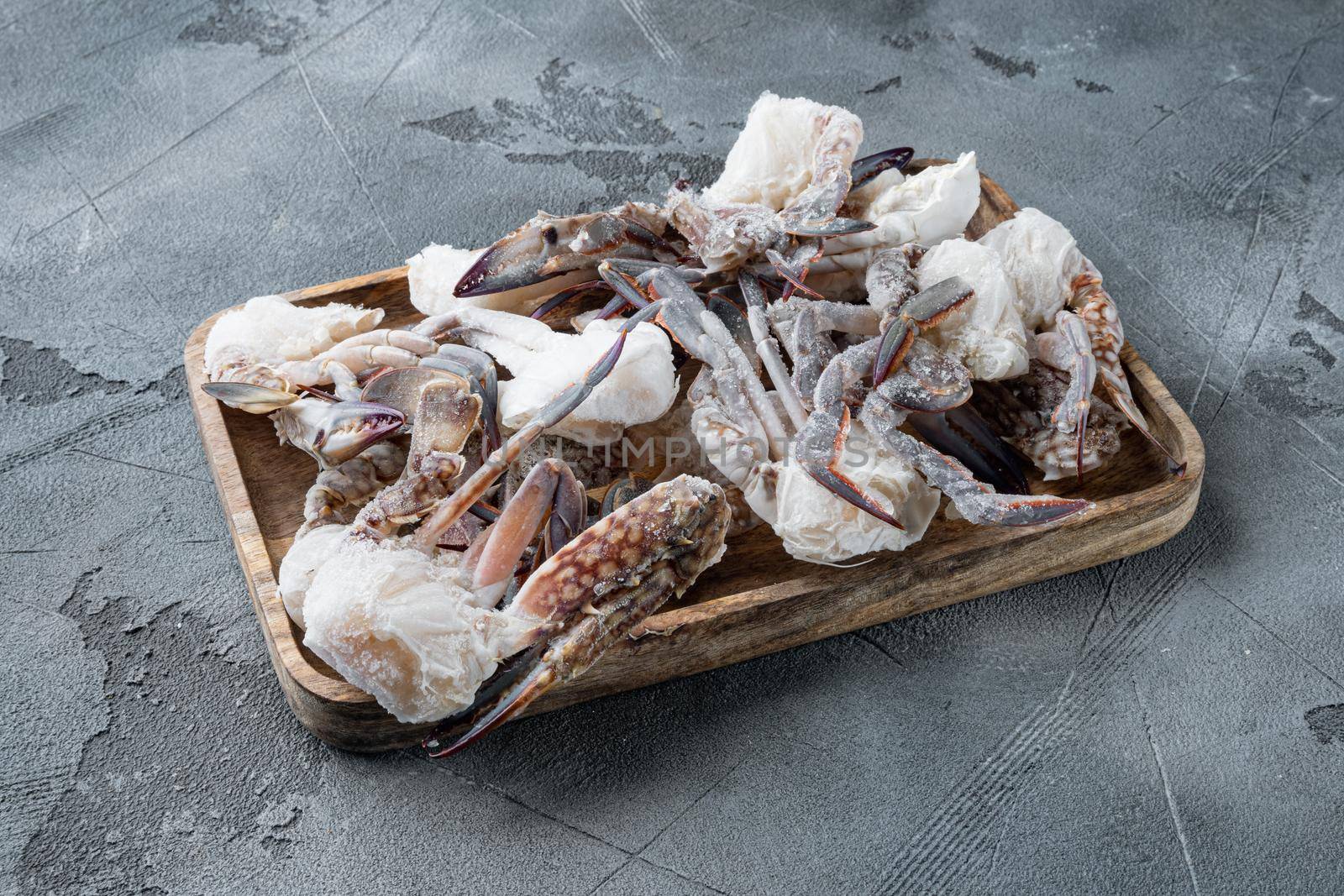 Horse crab, Blue crab, Flower crab frozen in ice set, on wooden tray, on gray background