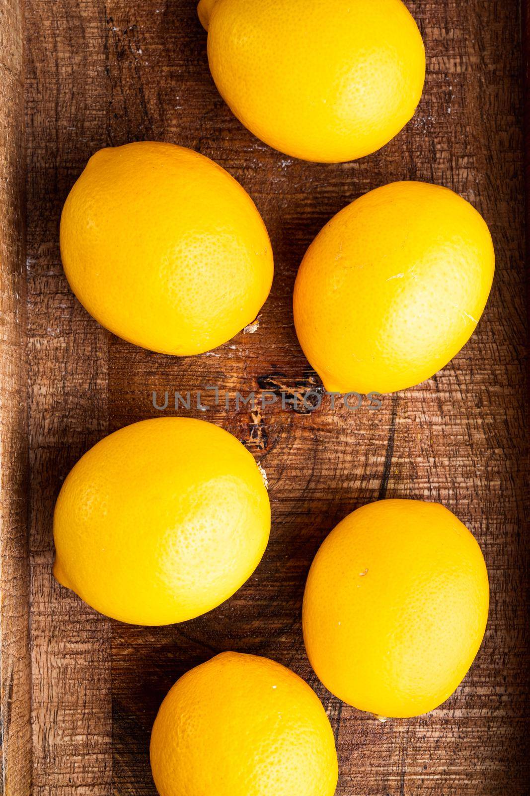 Ripe lemons set, in wooden box, on gray background, top view flat lay
