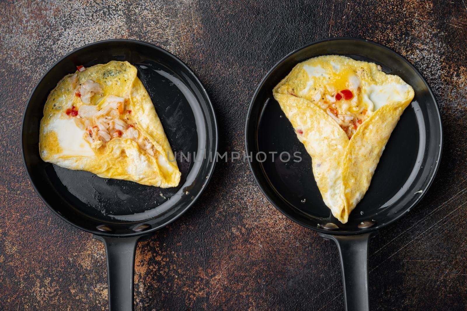 Spanish omelette, fresh red chilli, brown and white crabmeat, lemon, Cheddar cheese, eggs fried, on frying iron pan, on old dark rustic background, top view flat lay