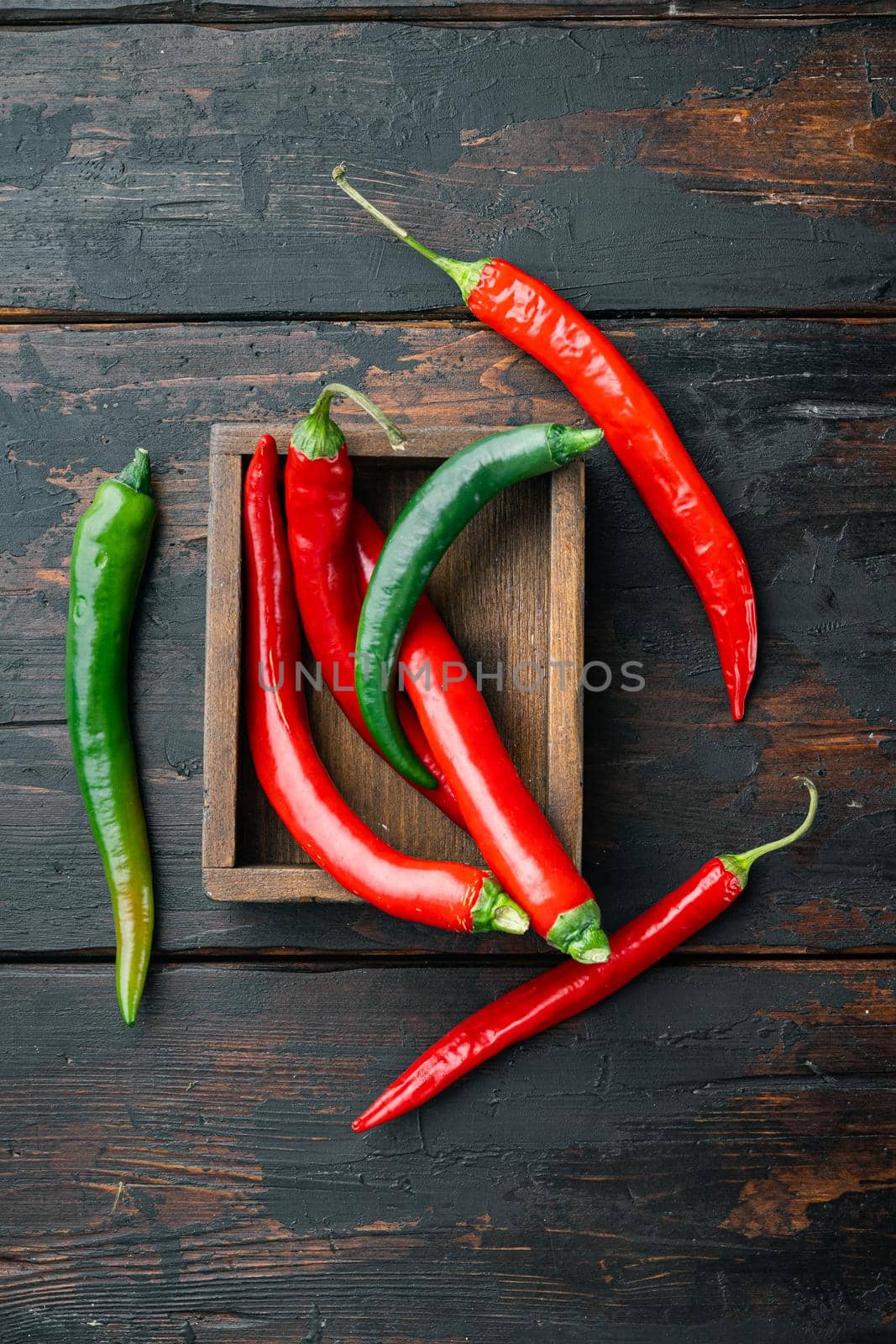 Ripe Red and green chili pepper set, in wooden box, on dark wooden background, top view flat lay