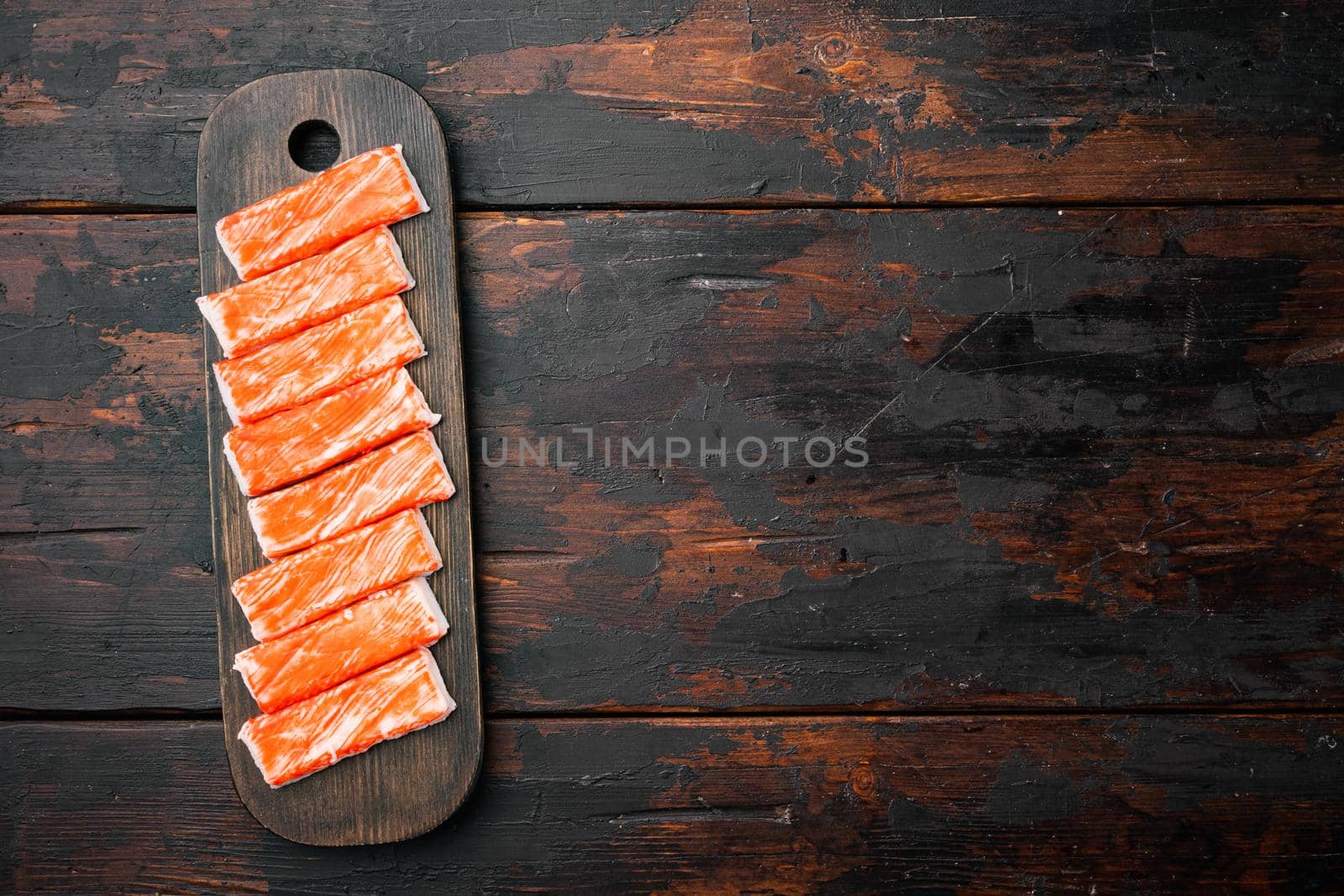 Asian snack surimi set, on wooden cutting board, on dark wooden background, top view flat lay , with copyspace and space for text