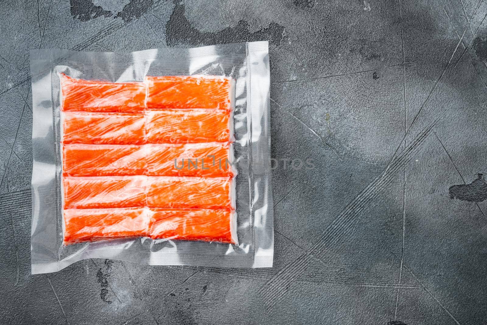 Crab stick surimi vacuum pack set, on gray background, top view flat lay , with copyspace and space for text