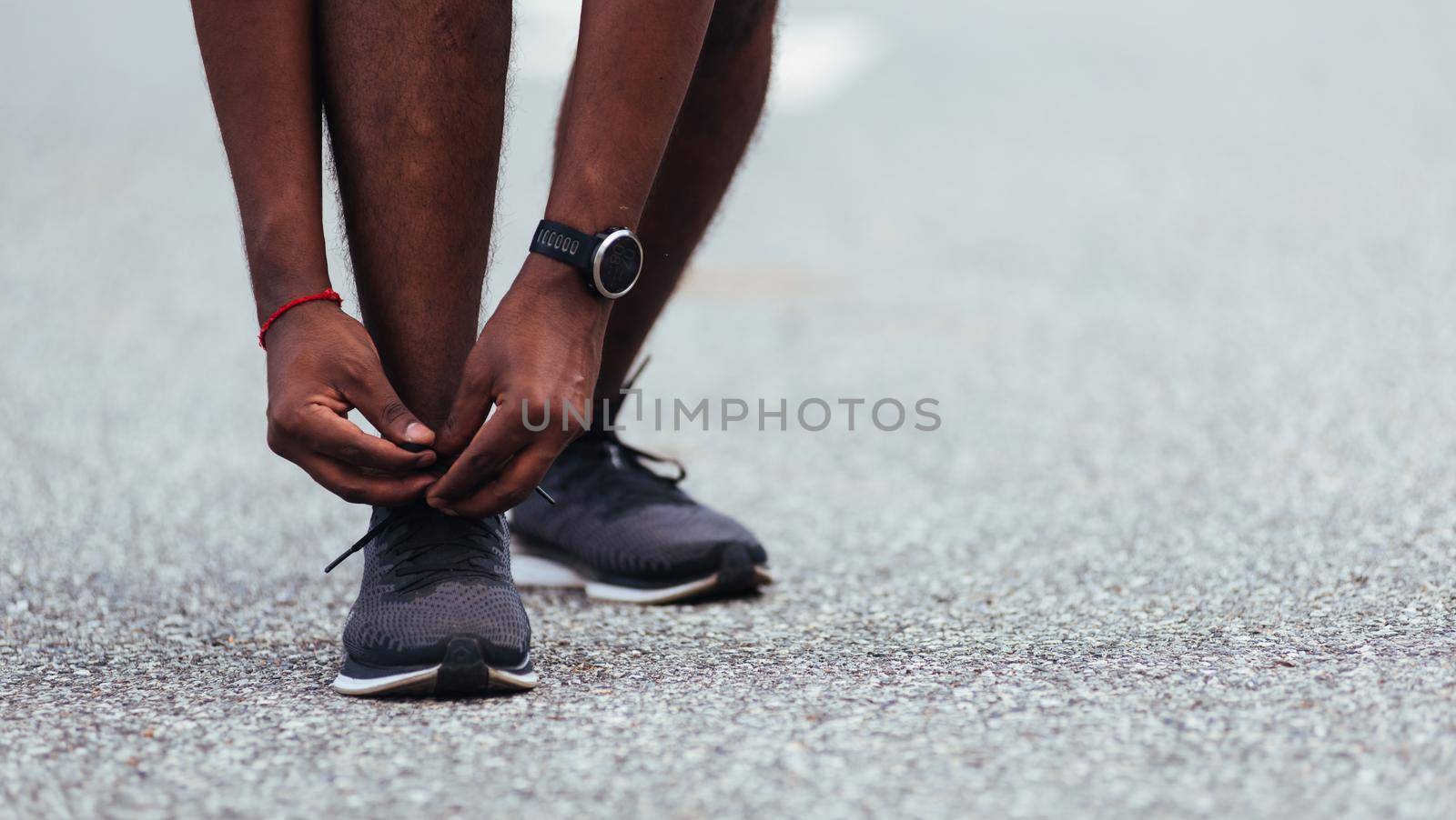 Close up Asian sport runner black man standing he trying shoelace running shoes getting ready for jogging and run at the outdoor street health park, healthy exercise workout concept