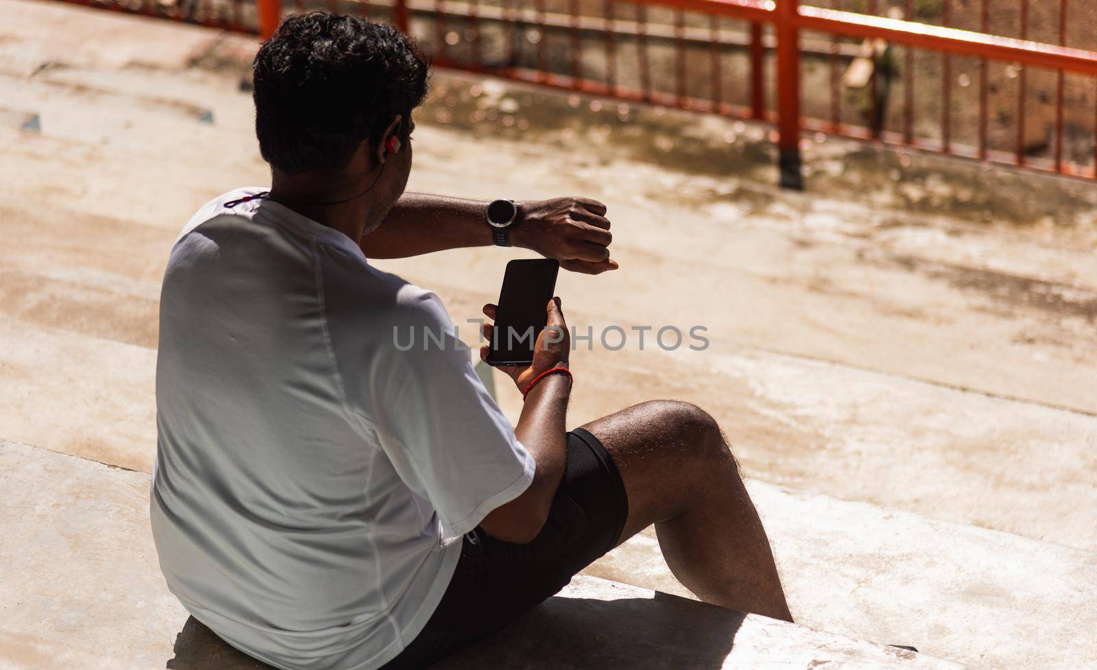 sport runner black man wear modern time smart watch and sync to a smartphone by Sorapop