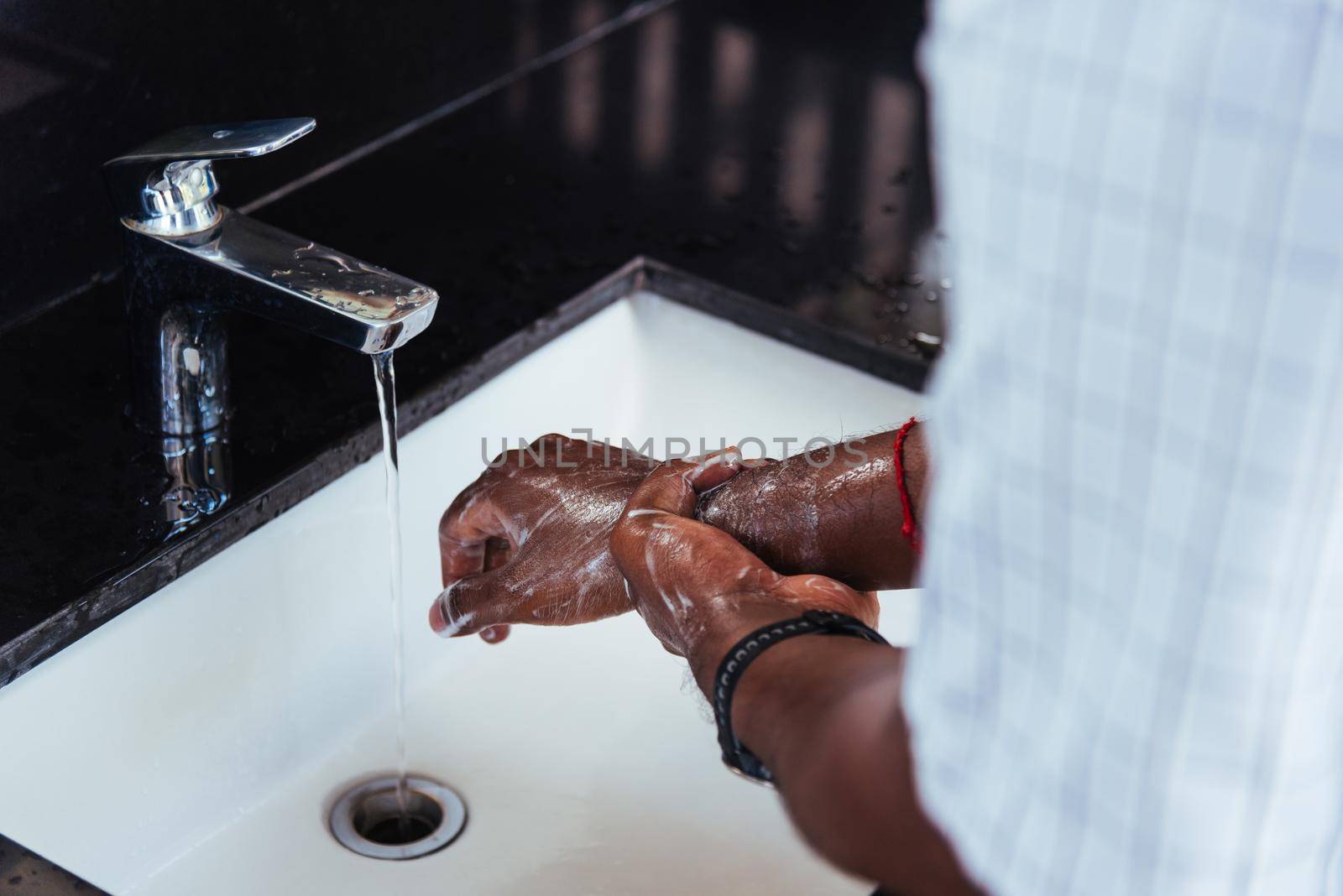 man hands rubbing with soap and water in sinks by Sorapop