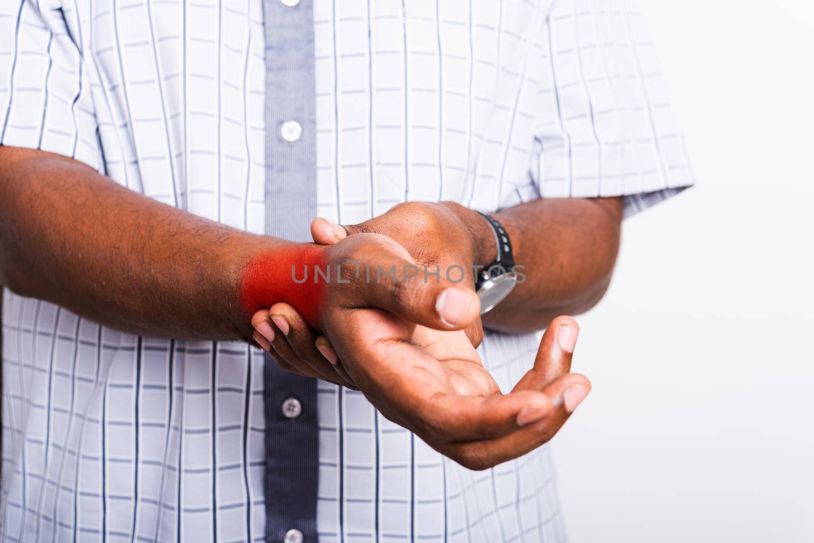 black man holds his wrist hand injury, feeling pain by Sorapop