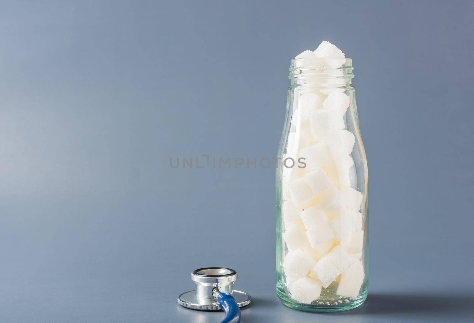 Glass bottle full of white sugar cube by Sorapop