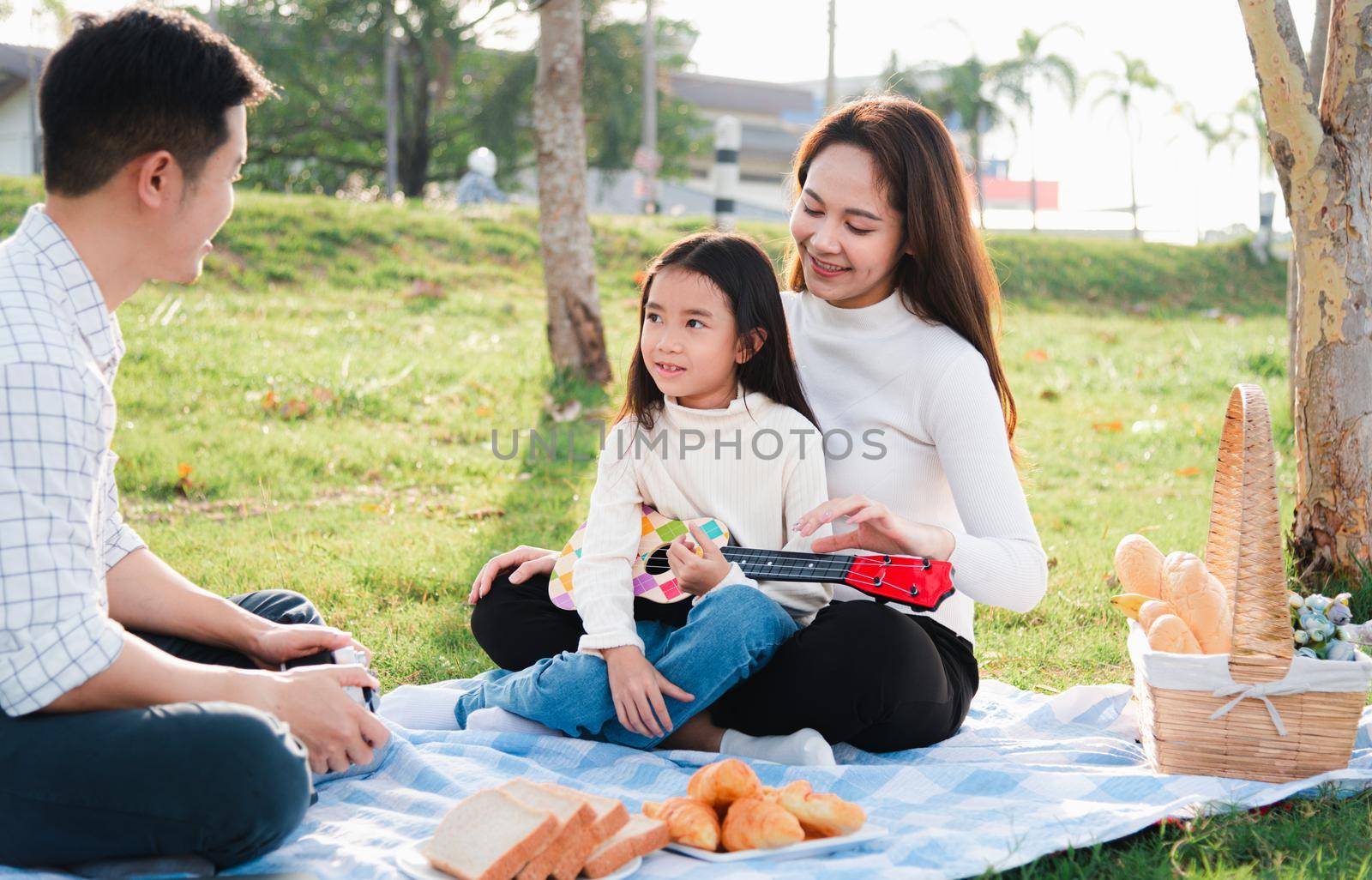 young family father, mother and children having fun and enjoying outdoor together by Sorapop