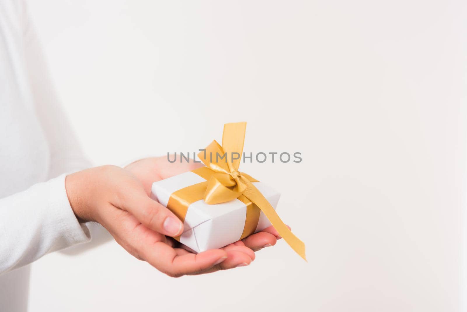 Valentine's Day. Woman beauty hands holding small gift package box present wrapped paper with ribbon isolated on white background, Birthday, New year, Christmas, holiday background concept