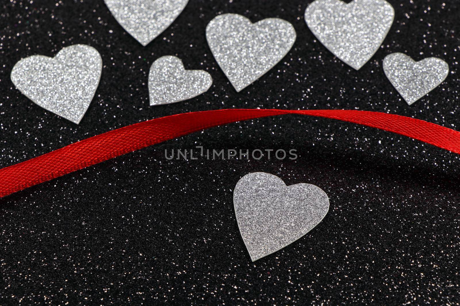 Silver Hearts And Red Ribbon On Textured Black by jjvanginkel