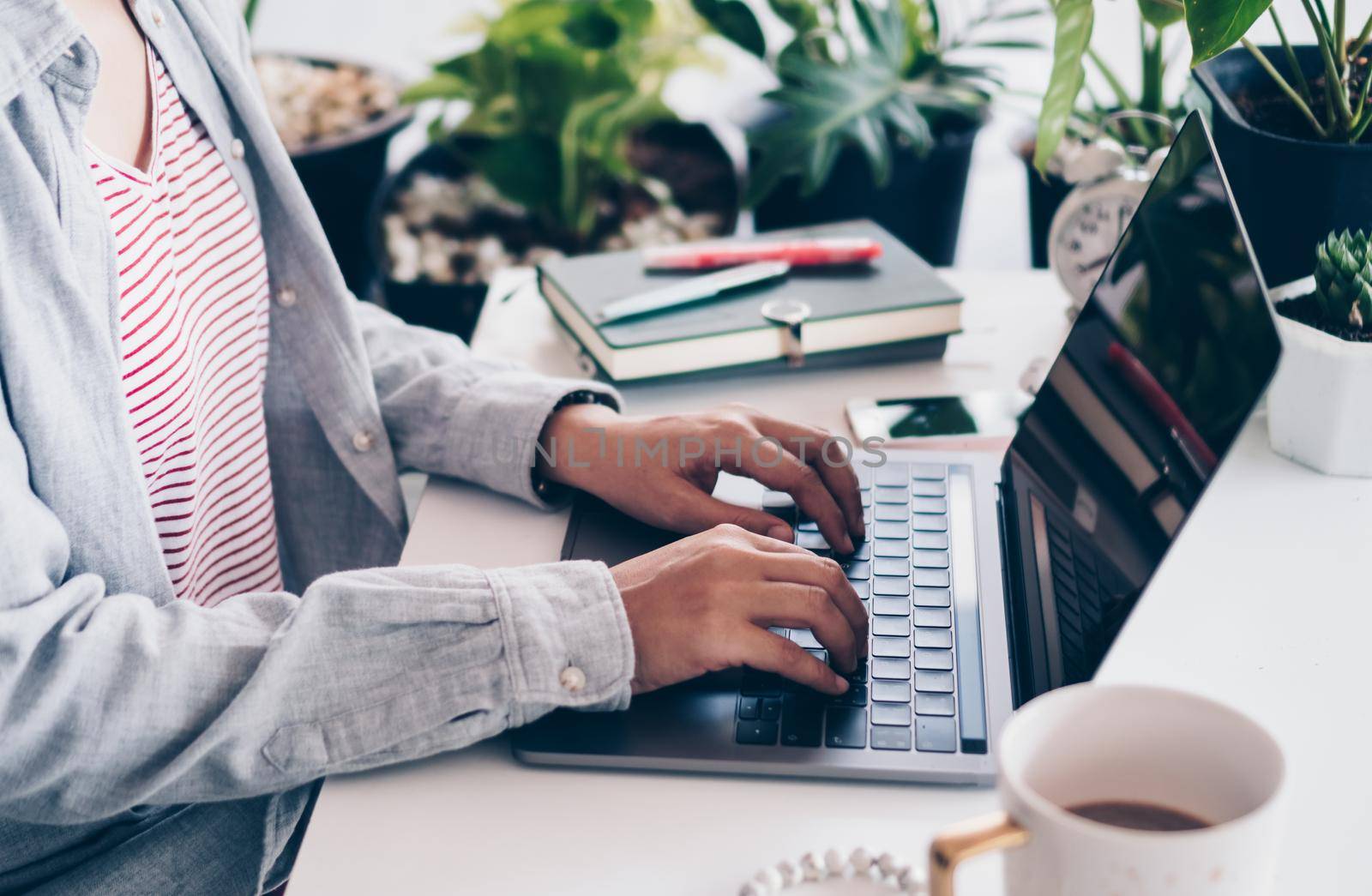 Woman is working on clean nature workspace at home with laptop, planner notebook and calculator. Business finance office. by Suwant